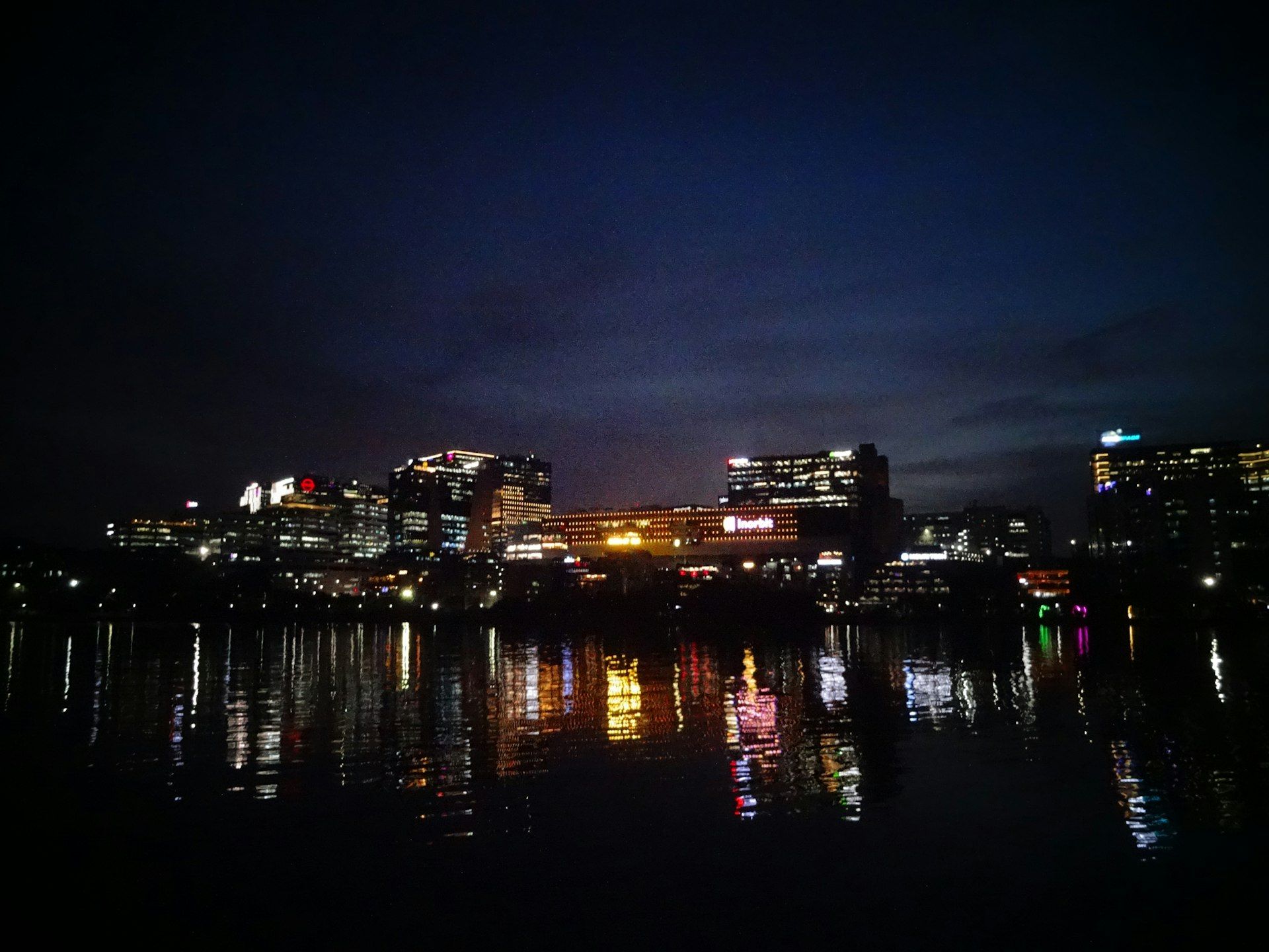 City skyline at night with water reflections.