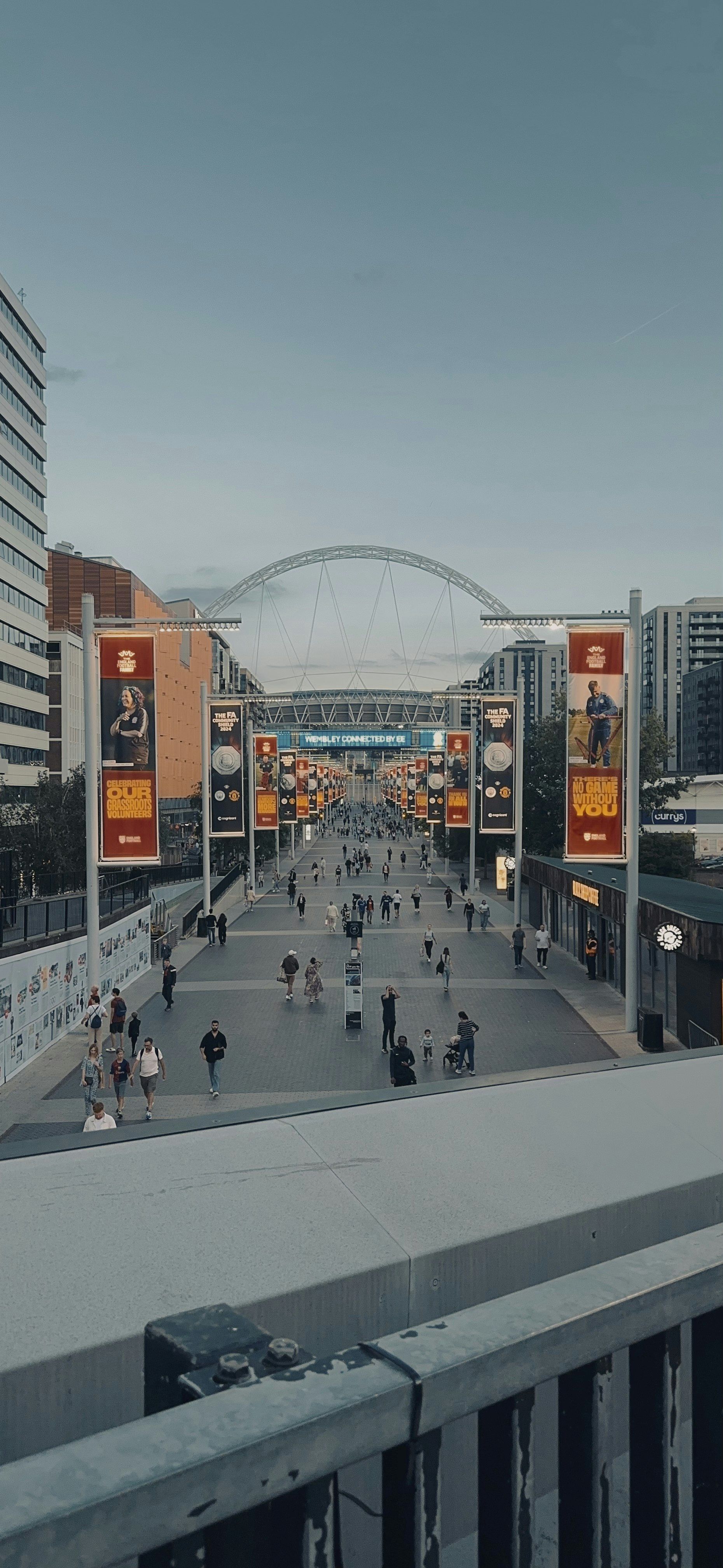 People walk on the walkway towards the stadium.